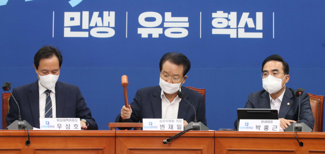 더불어민주당 변재일 중앙위 의장이 13일 오전 국회에서 열린 중앙위원회에서 개회를 선언하고 있다. 왼쪽부터 우상호 비상대책위원장, 변 의장, 박홍근 원내대표. 연합뉴스