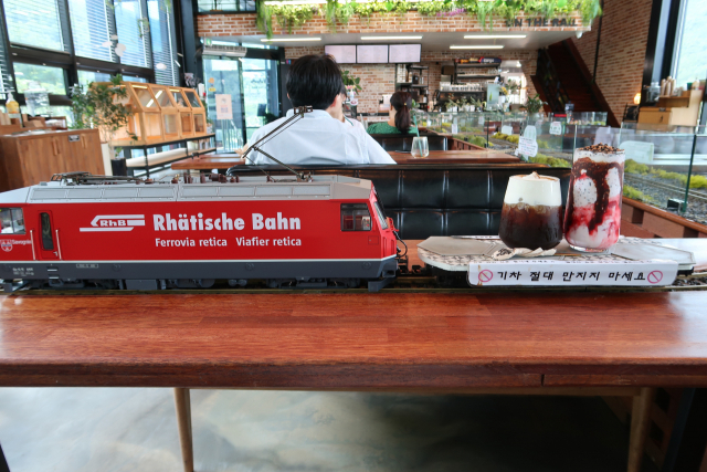 모형 기차가 지정된 테이블로 음료를 배달하는 모습.