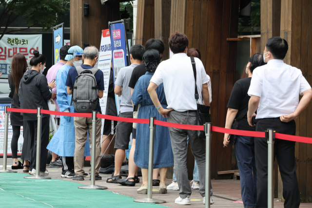 코로나19 신규 확진자 수가 3만9196명을 기록한 지난 14일 오전 서울 송파구 보건소 선별검사소에서 시민들이 줄을 서서 검사 순서를 기다리고 있다. 연합뉴스