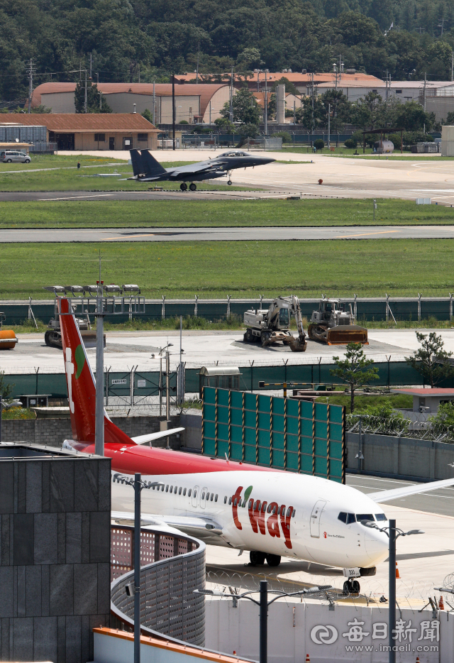 지난 2020년 3월 대구국제공항 활주로에 여객기가 계류 중인 가운데 F-15K 전투기가 임무를 마치고 대구 공군기지로 귀환하고 있다. 매일신문DB