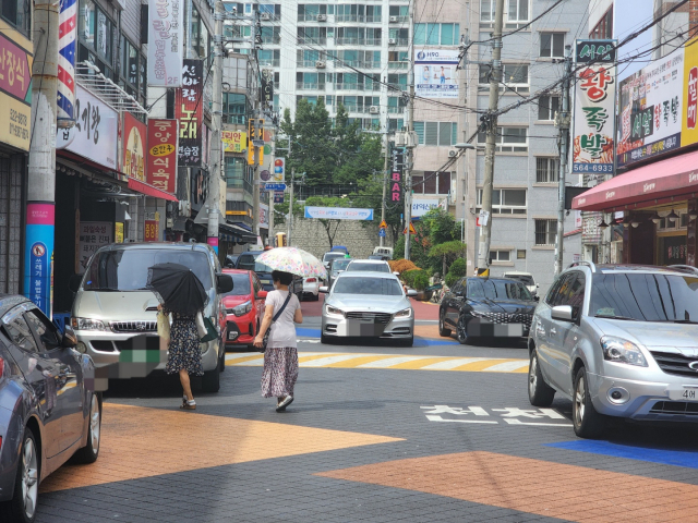 지난 15일 오후 2시쯤 찾은 대구 달서구 용산큰시장. 아스팔트 위에 파랑과 주황색 등으로 칠해진 이 일대는 보행자 우선도로다. 운전자들은 보행자를 만났을 때 서행 및 일시정지 의무가 있지만, 현실에서는 잘 지켜지지 않고 있다. 임재환 기자