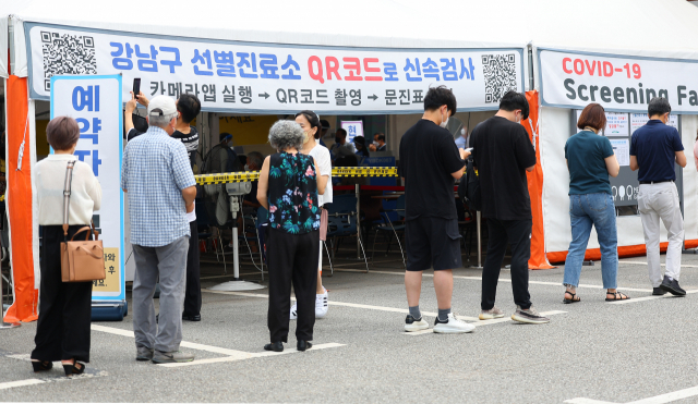 코로나19가 재확산하고 있는 18일 오전 서울 강남구보건소에 설치된 임시선별진료소를 찾은 시민들이 검사 순서를 기다리고 있다. 연합뉴스