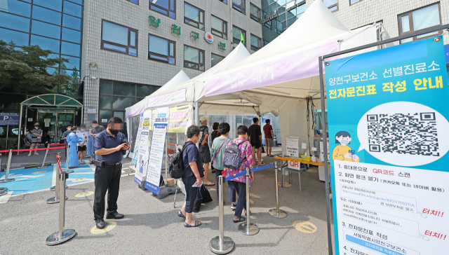 월요일 기준 코로나19 신규확진자 수가 12주 만에 최다를 기록한 18일 오전 서울 양천구보건소에 마련된 선별진료소에서 시민들이 검사 순서를 기다리고 있다. 연합뉴스