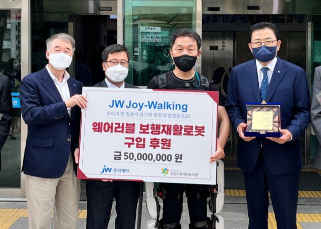 (왼쪽부터) 백경학 푸르메재단 상임이사, 이학준 과천시장애인복지관장, 웨어러블 로봇재활 참여자 이희성 씨, 신영섭 JW중외제약 대표이사가 기부금 전달식에서 기념사진을 촬영하고 있다.