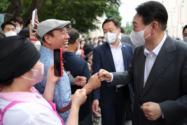 윤석열 대통령이 20일 오후 경기도 성남시 분당구 목련마을 주공1단지 아파트를 방문, 주민들과 인사하고 있다. 윤 대통령 이날 단지내 중탑종합사회복지관에서 제3차 비상경제민생회의를 주재했다. 연합뉴스