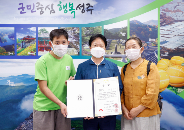 경북 성주군 장성빈(왼쪽)) 씨가 제20회 무안 전국 승달국악대제전에서 장애인부 판소리 부문 대통령상을 수상 한 뒤 이병환 성주군수와 기념촬영을 하고 있다. 성주군 제공