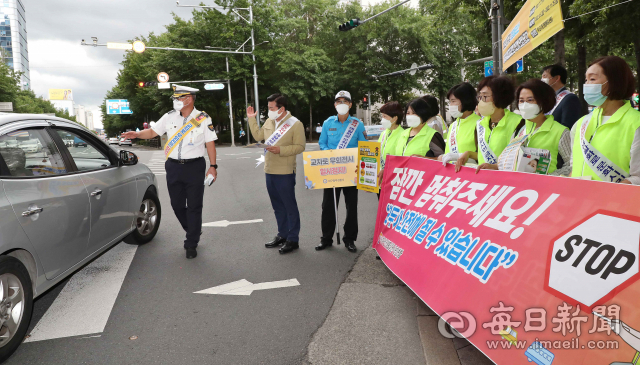 7월 21일 오후 대구 중구 종각네거리에서 열린 보행자 보호의무 강화 교통안전 캠페인에서 중구청과 중부경찰서, 모범운전자회, 대구안전생활실천시민연합 등 관계자들이 교차로 우회전 차량들을 대상으로 보행자 중심의 