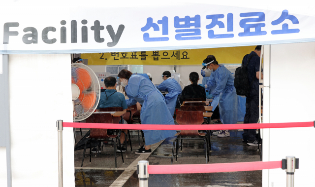 21일 오전 서울 강남구보건소 코로나19 선별진료소에서 의료진이 검사를 받으려는 시민들을 안내하고 있다. 연합뉴스