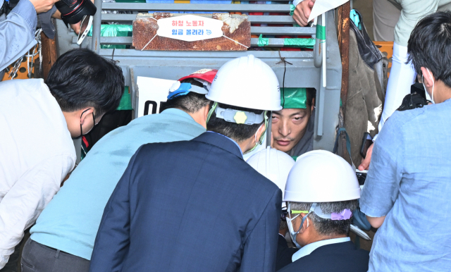 이정식 고용노동부 장관이 19일 오후 경남 거제시 아주동 대우조선해양 옥포조선소 파업 현장을 방문해 조선소 독 화물창 바닥에 가로, 세로, 높이 각 1ｍ 철 구조물 안에서 농성 중인 유최안 금속노조 거제통영고성 조선하청지회 부지회장과 면담하고 있다. 연합뉴스