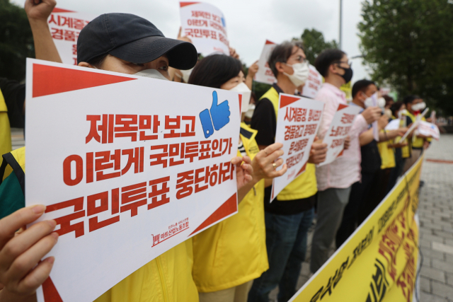 한 마트노동자가 21일 서울 용산구 대통령 집무실 인근에서 열린 대형마트 의무휴업 폐지 투표반대 기자회견에서 팻말을 들고 있다. 대통령실은 전날 대형마트 의무휴업 폐지가 포함된 우수 국민제안 10건을 발표하고 온라인 투표를 통해 그 중 3건을 뽑아 실제 국정에 반영하겠다고 밝혔다. 연합뉴스