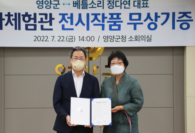 오도창 영양군수(왼쪽)와 정다연 베틀소리 대표가 지난 22일 영양군 석보면 두들마을 역사문화체험관에 전시될 전통복식에 대한 무상 기증 협약식을 체결하고 기념촬영을 하고 있다. 영양군 제공