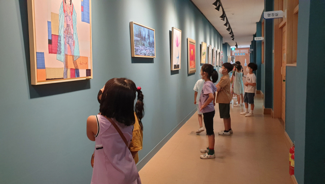 학교 안 교실 복도에 설치된 작은 미술관을 찾은 학생들이 작품을 감상하고 있다. 동부초 제공