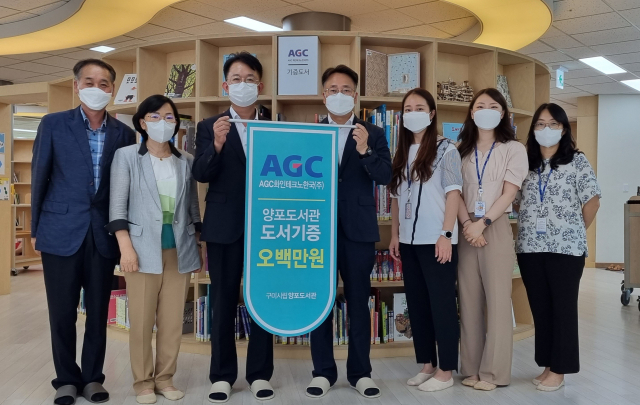 AGC화인테크노한국㈜ 김춘경(가운데) 사무부장을 비롯한 임직원들이 구미시 평생학습원, 도서관 관계자들에게 도서 기증식을 하며 기념촬영하고 있다. AGC화인테크노한국㈜ 제공