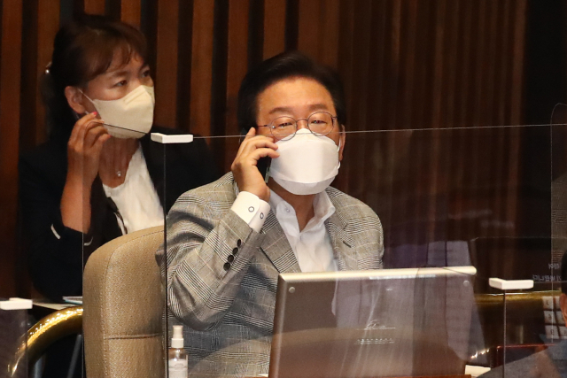 더불어민주당 이재명 의원이 26일 국회 본회의장에서 열린 경제 분야 대정부질문에 참석해 통화하고 있다. 연합뉴스
