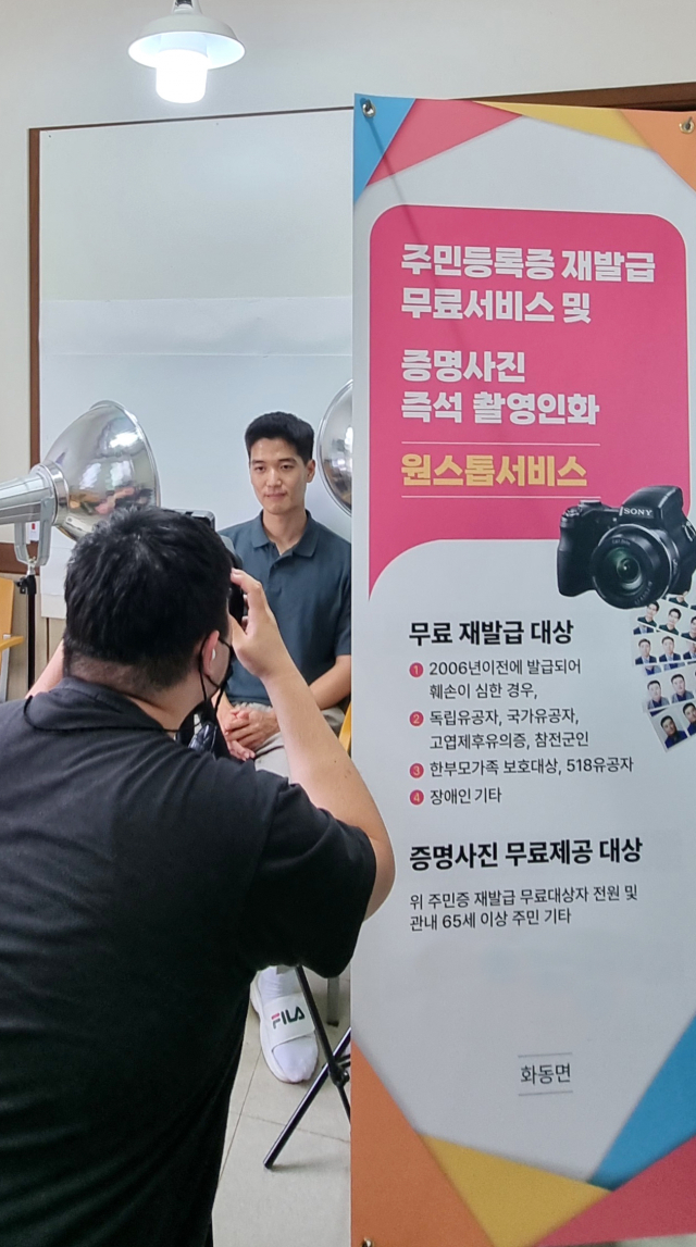 상주시 화동면사무소에 마련된 주민등록재발급무료서비스 코너. 사진촬영스튜디오까지 마련된 가운데 공무원이 증명사진을 찍고 있다. 화동면사무소 제공