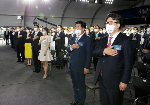 국민의힘 권성동 당대표 직무대행 겸 원내대표가 28일 오전 울산시 현대중공업에서 열린 차세대 이지스구축함 정조대왕함 진수식에서 국기에 경례를 하고 있다. 연합뉴스