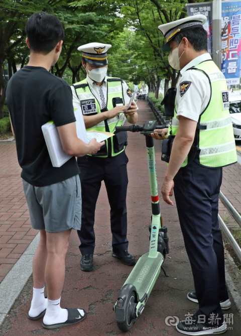 지난 8월 대구 달서구 신당네거리 인근에서 경찰이 헬멧을 착용하지 않은 채 전동킥보드를 탄 사람을 안전모 미착용으로 단속하고 있다. 매일신문DB
