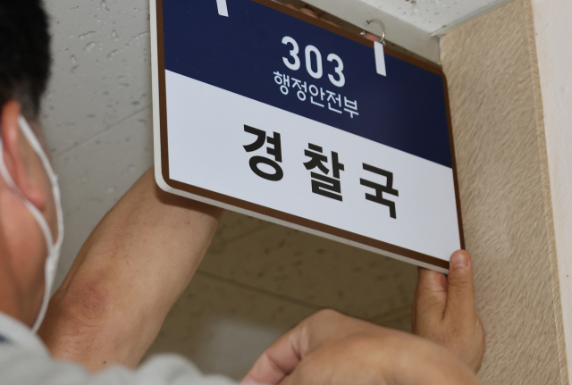 행안부 경찰국이 2일 공식 출범하는 가운데 1일 오후 정부서울청사에서 관계자들이 경찰국 안내판을달고 있다. 연합뉴스