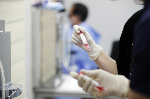 코로나19 신규 확진자 수가 11만 명을 넘어선 2일 광주 북구 상시 선별진료소에서 보건소 의료진이 검체통을 확인하고 있다. 연합뉴스