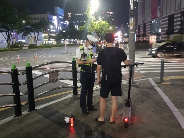 3일 밤 10시 동아 백화점 인근 대로에서 전동 킥보드를 이용하던 10대 남성에게 헬멧 미착용으로 범칙금이 부과됐다. 김세연 기자