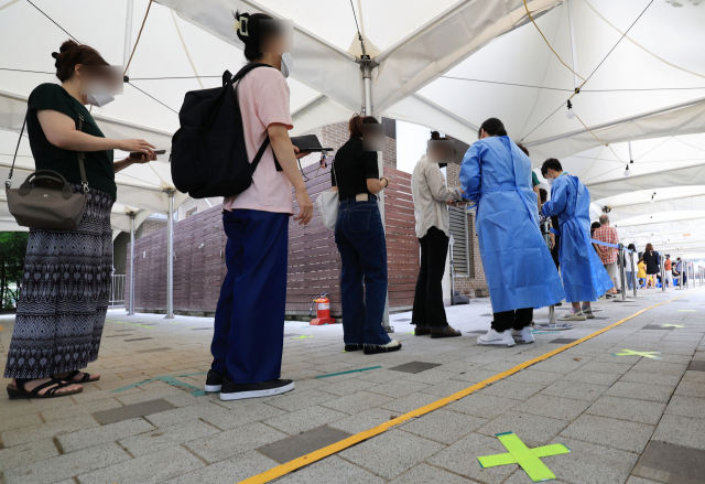 5일 서울 마포구 보건소 코로나19 선별진료소를 찾은 시민들이 검사를 받기 위해 차례를 기다리고 있다. 중앙방역대책본부는 이날 0시 기준으로 코로나19 신규 확진자가 11만2901명 늘었다고 밝혔다. 연합뉴스