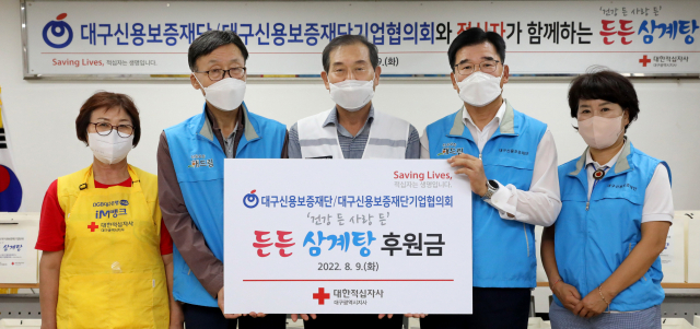 왼쪽부터 최영순 적십자봉사회 달서구지구협의회장, 한효동 대구신용보증재단기업협의회 회장, 박명수 대구적십자사 회장, 황병욱 대구신용보증재단 이사장, 권숙자 달서구의원이 후원금을 전달하고 기념촬영을 하고 있다