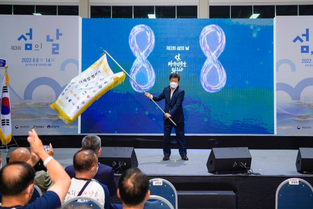 지난 14일 전북 군산에서 열린 제3회 섬의 날 폐막식에서 남한권 울릉군수가 내년도 행사의 성공적 개최를 기원하며 행사기를 흔들고 있다. 울릉군 제공.