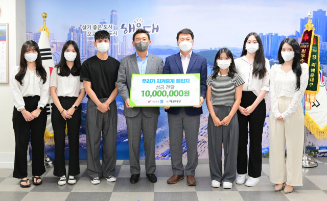 조우현(왼쪽 4번째) 대선주조 대표와 김성수(왼쪽 5번째) 부산 해운대구청장이 코로나19 백신 접종 후 홀어머니가 사망하면서 남겨진 세 자매를 돕고자 모금을 진행한 부산 소재 대학인 동아대 관광경영학과 박연정(왼쪽부터), 노승연, 한성욱, 김민정, 이강이, 박주은 씨와 기념 촬영을 하고 있다. 대선주조 제공