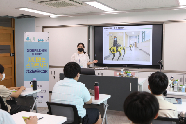 현대엔지니어링 스마기술센터 정혜영 책임매니저가 경신중학교 학생들을 대상으로 스마트건설기술 및 스마트시티에 대해 설명하는 모습.