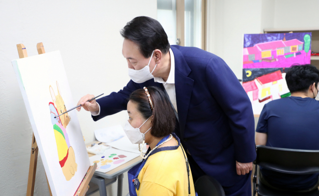 윤석열 대통령이 18일 오후 서울 강남구 역삼동 충현복지관을 방문, 발달장애인 교육생들의 회화 수업을 참관해 그림을 그리고 있다. 연합뉴스
