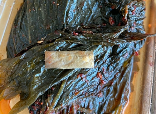 A씨가 깻잎을 먹다 뱉어냈다는 담배꽁초의 필터 부분. 제보자 A씨 제공. 연합뉴스