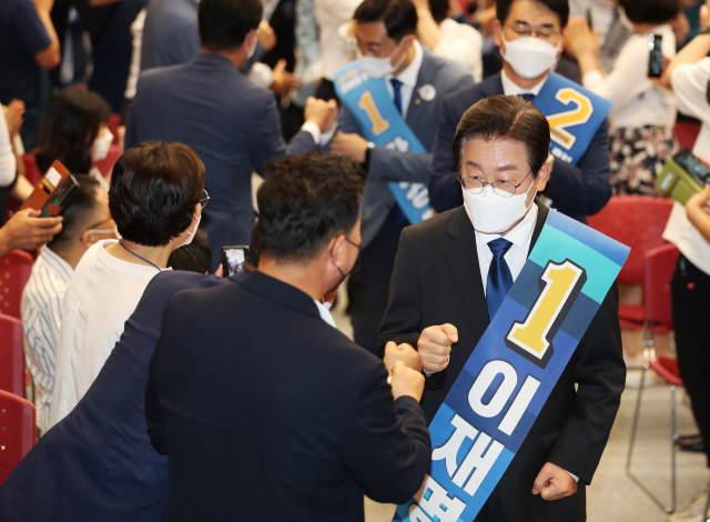 21일 오후 광주 김대중컨벤션센터에서 열린 더불어민주당 당 대표 및 최고위원 후보자 광주 합동연설회에서 이재명 당 대표 후보가 한 참석자와 인사하고 있다. 연합뉴스