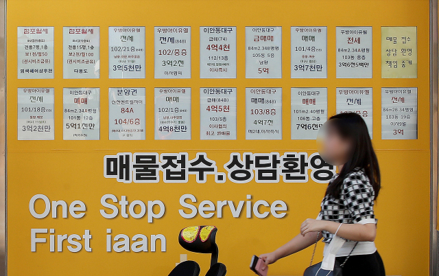 21일 오후 대구 시내의 한 공인중개사 사무소 앞에 붙은 부동산 가격표 앞으로 시민이 길을 지나고 있다. 김영진 기자 kyjmaeil@imaeil.com