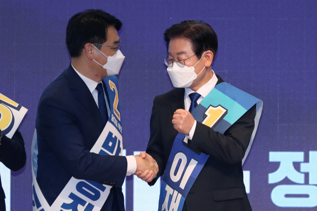 21일 오후 광주 김대중컨벤션센터에서 열린 더불어민주당 당 대표 및 최고위원 후보자 광주 합동연설회에서 이재명(오른쪽) 당 대표 후보가 투표 결과 발표가 끝난 뒤 박용진 후보와 악수하고 있다. 이 후보는 호남에서도 이틀 연속 압승을 거뒀다. 연합뉴스