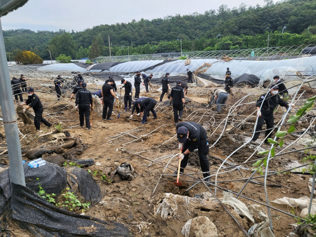 해양경찰관들이 19일 경기도 성남시 관내 집중호우 피해 농가를 찾아 수해복구 작업을 하고 있다. 연합뉴스