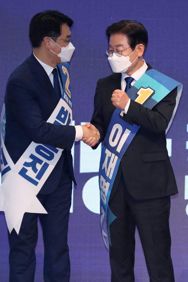21일 오후 광주 김대중컨벤션센터에서 열린 더불어민주당 당 대표 및 최고위원 후보자 광주 합동연설회에서 이재명(오른쪽) 당 대표 후보가 투표 결과 발표가 끝난 뒤 박용진 후보와 악수하고 있다. 이 후보는 호남에서도 이틀 연속 압승을 거뒀다. 연합뉴스