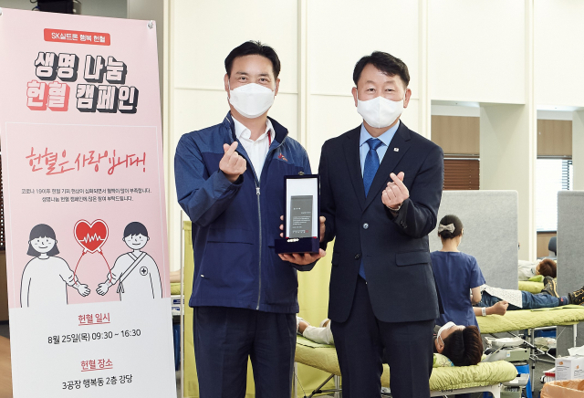 SK실트론 김학승(왼쪽) SHE경영단장이 이건문 대구경북혈액원장으로부터 감사패를 받고 기념촬영하고 있다. SK실트론 제공