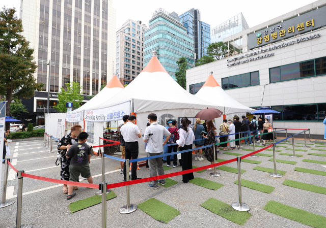 25일 오전 서울 강남구보건소에 마련된 코로나19 임시선별진료소를 찾은 시민들이 검사를 기다리고 있다. 중앙방역대책본부에 따르면 이날 0시 기준 신규확진자 수는 11만3371명을 기록했다. 연합뉴스