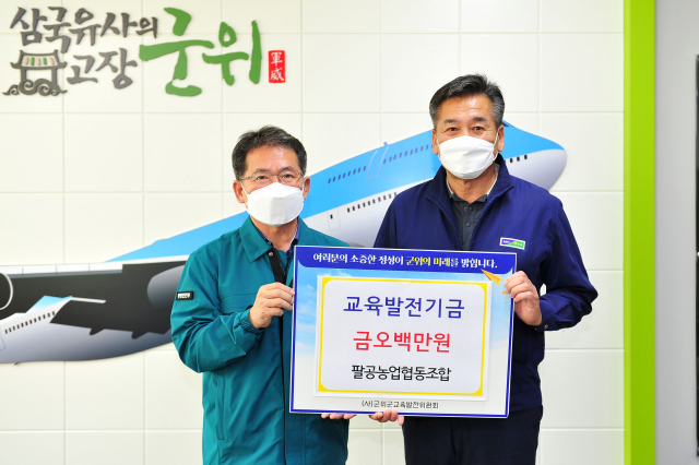 이삼병(오른쪽) 경북 군위군 팔공농협 조합장이 군위군교육발전위원회에 교육발전기금 500만원을 기탁하고, 김진열 군수와 기념 사진을 촬영하고 있다. 군위군 제공