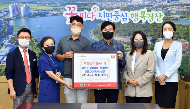 곽기성(왼쪽 세 번째) ㈜허니스트 대표가 경산시에 유아용 위생용품 200세트를 기탁했다. 경산시 제공