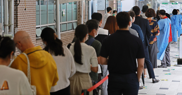 신종 코로나바이러스 감염증 신규 확진자 수 4만3142명을 기록한 29일 오전 서울 마포구보건소 코로나19 선별진료소를 찾은 시민들이 검사를 위해 줄을 서 있다. 연합뉴스