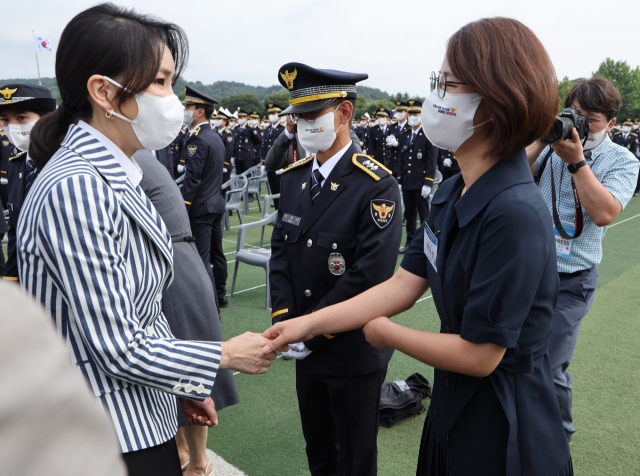 김건희 여사가 19일 충북 충주시 중앙경찰학교에서 열린 310기 졸업식에서 신임 경찰 가족과 인사하고 있다. 연합뉴스