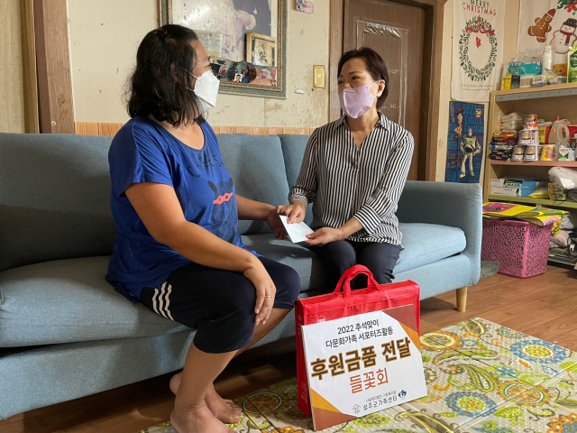 경북 성주군청 여성공무원들의 봉사단체인 들꽃회 이미화(사진 오른쪽) 회장이 다문화가정을 찾아 결혼이주여성에게 후원금품을 전달하고 있다. 들꽃회 제공
