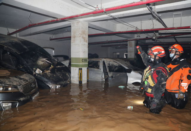7일 오후 2명이 구조되고 7명이 숨진 것으로 파악된 경북 포항시 한 아파트 지하주차장 내부에서 소방 대원들이 구조 당시 상황을 설명하고 있다. 연합뉴스