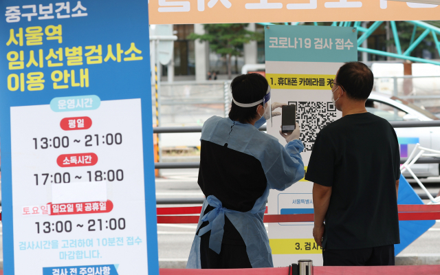 지난 11일 오후 서울역 앞에 마련된 코로나19 선별검사소에서 관계자가 시민을 안내하고 있다. 연합뉴스