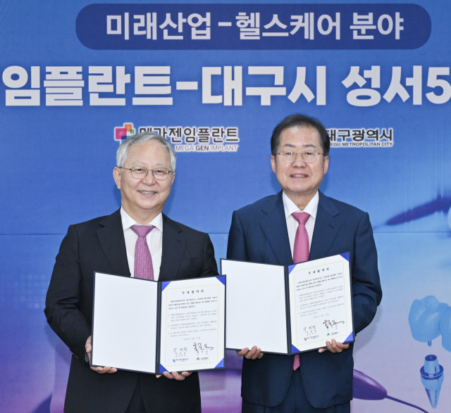 홍준표 대구시장(오른쪽)과 박광범 메가젠임플란드 대표가 14일 2공장 설립 투자협약을 체결했다. 대구시 제공