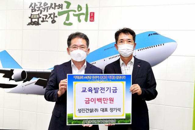 경북 군위군의 성진건설 장기석(오른쪽) 대표가 김진열(왼쪽) 군위군교육발전위원회 이사장에게 교육발전기금을 기탁하고 기념 사진을 촬영하고 있다. 군위군 제공