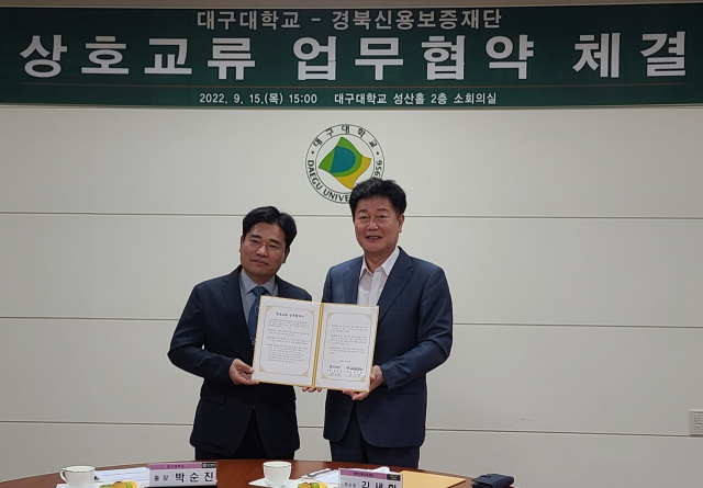 김세환(오른쪽) 경북신용보증재단 이사장과 박순진 대구대 총장이 산학협력을 위한 업무협약을 체결하고 있다. 경북신용보증재단 제공
