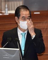 한덕수 국무총리가 20일 오후 국회에서 열린 본회의에서 답변을 하기 전 안경을 고쳐 쓰고 있다. 연합뉴스