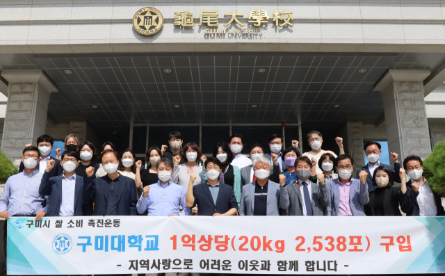 구미대학교 교직원들이 본관 앞에서 1억원 상당의 쌀을 구입하고 기념촬영하고 있다. 구미대 제공